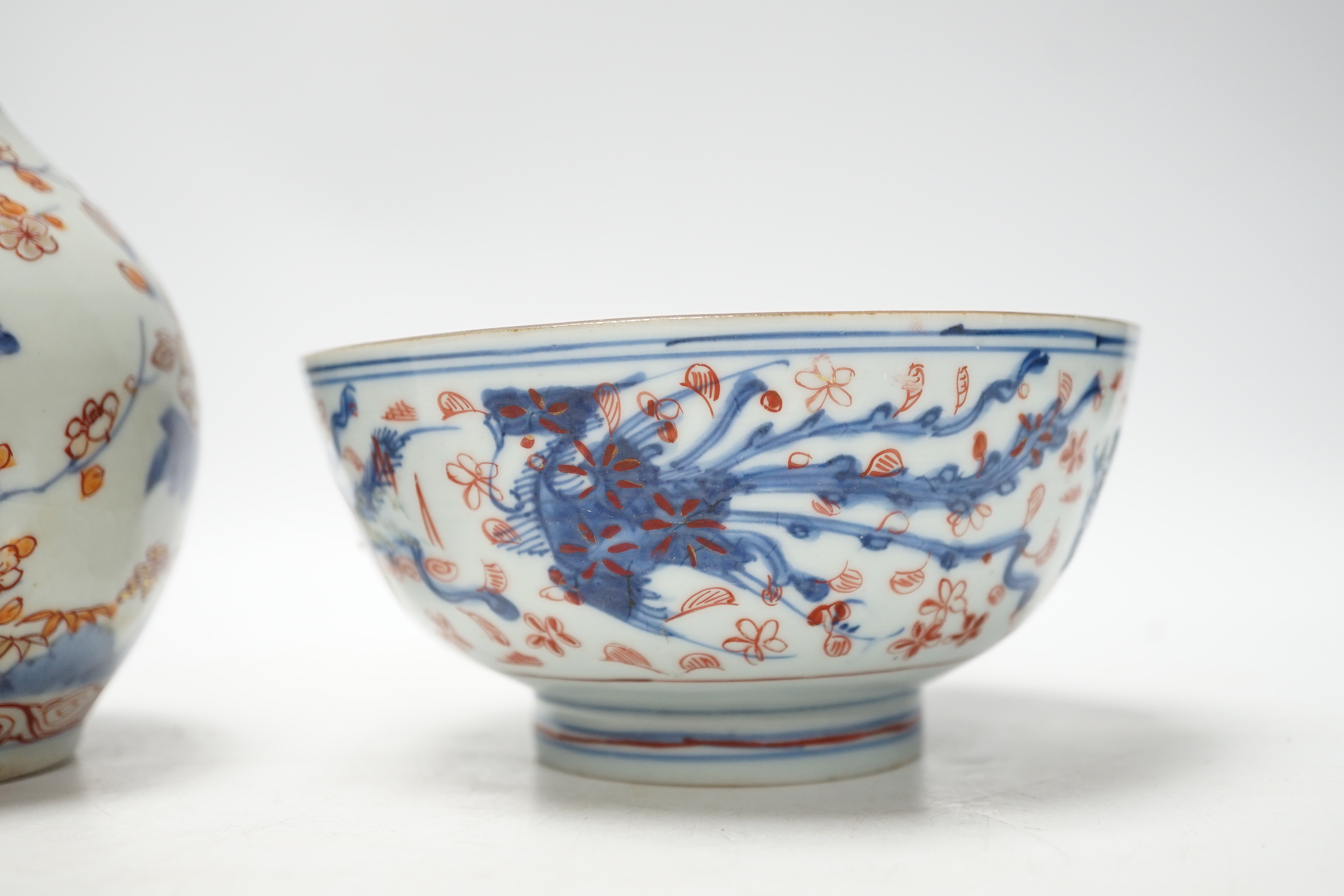 An 18th century Japanese Imari sake flask and a Chinese clobbered blue and white bowl (a.f), tallest 20cm